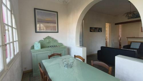 une salle à manger avec une table et des chaises vertes dans l'établissement Maison Sarah Bernhardt tout confort, à Andernos-les-Bains