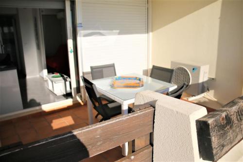 d'une table et de chaises avec un gâteau. dans l'établissement Appart 486, Port nature 4 au village naturiste, au Cap d'Agde