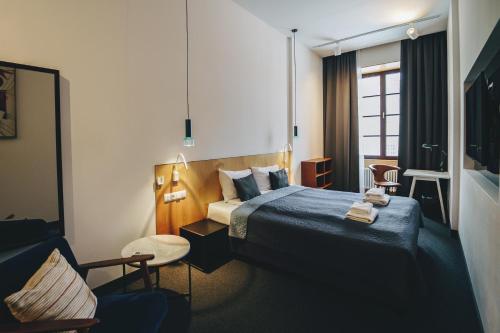 ルブリンにあるAvatary Miastaのベッドと椅子付きのホテルルーム