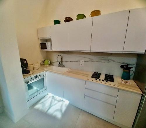 a kitchen with white cabinets and a sink at Li Frati Suite in Lecce