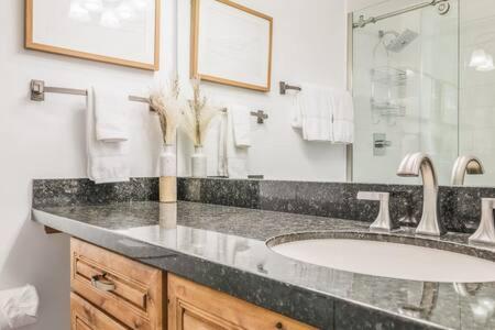 uma casa de banho com um lavatório e um espelho grande em New Listing 3BR 3BA Condo - Steps to Gondola em Aspen