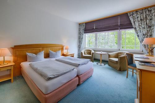 a hotel room with a large bed and a desk at Idyll Am Wolgastsee in Korswandt