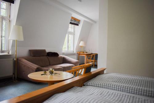 a living room with a couch and a table at Meeressterne Hotel Idyll Am Wolgastsee in Korswandt