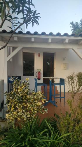 a small house with a blue table in front of it at Duna Parque Beach Club - Duna Parque Resorts & Hotels in Vila Nova de Milfontes