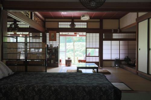 a bedroom with a bed and a large window at 棚田ハウス in Murai