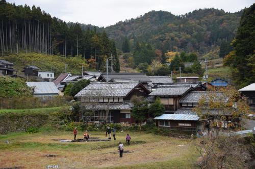 a group of people standing in front of a village at 棚田ハウス in Murai