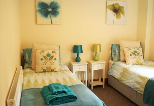 1 dormitorio con 2 camas individuales y 2 lámparas en Pet-Friendly Logburner Horse Stable Views en Hay-on-Wye