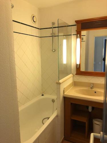 une salle de bain avec une baignoire et un lavabo et une baignoire dans l'établissement Logement entier : appartement en résidence - Lacanau, France, à Lacanau