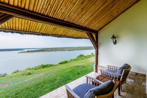 a screened in porch with a view of the water at Mweya Safari Lodge in Katwe