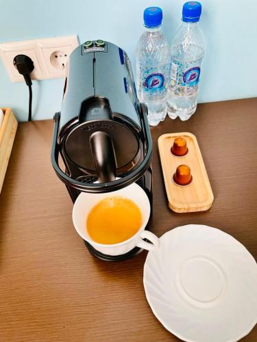 a tea kettle and a cup of coffee on a table at Hotel Shumon in Dushanbe