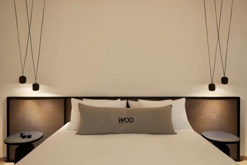 a bedroom with a white bed and two tables at Athens Woo Suites in Athens