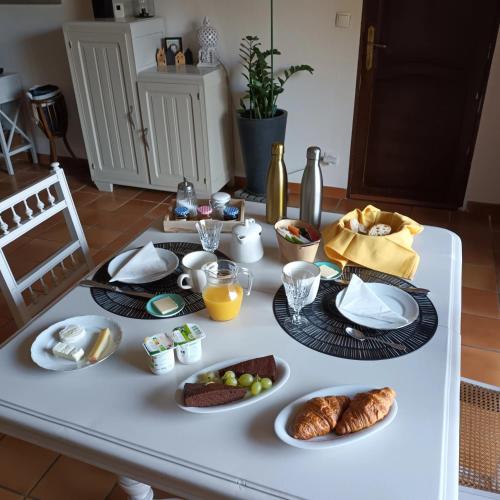 a table with a breakfast of croissants and food at Le Relais du Fraysse - Chambres d'hôtes in Le Fraysse