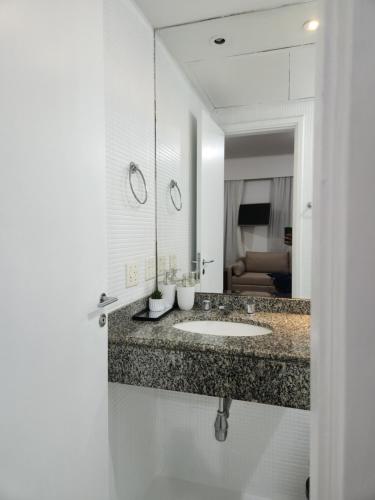 a bathroom with a sink and a mirror at Hotel Slavieiro Moema Suite Prime Familia in Sao Paulo