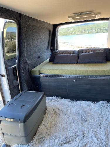 un lit et un tapis à l'arrière d'une camionnette dans l'établissement ANDWEGO, à Punat