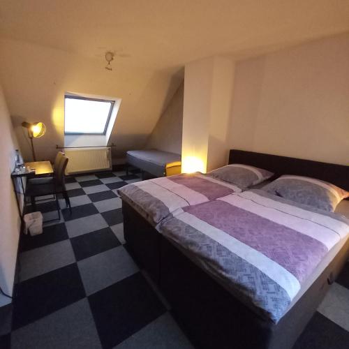 a bedroom with a bed and a checkered floor at Zur alten Metzgerei in Alf