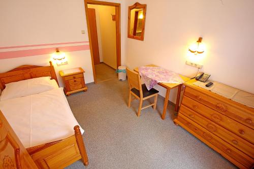 um quarto com uma cama, uma secretária e uma mesa em CProoms24 em Miesenbach