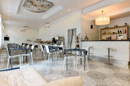 un restaurante con mesas y sillas y un bar en HOTEL BLUMARIN en Lido di Jesolo