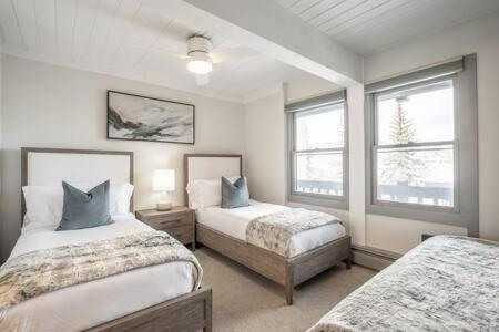 a bedroom with two beds and two windows at Renovated 2 BR Condo w Hot Tub -Mountain Views! in Snowmass Village