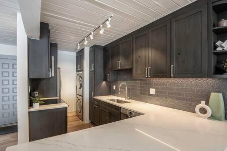a kitchen with black cabinets and a white counter top at Renovated 2 BR Condo w Hot Tub -Mountain Views! in Snowmass Village