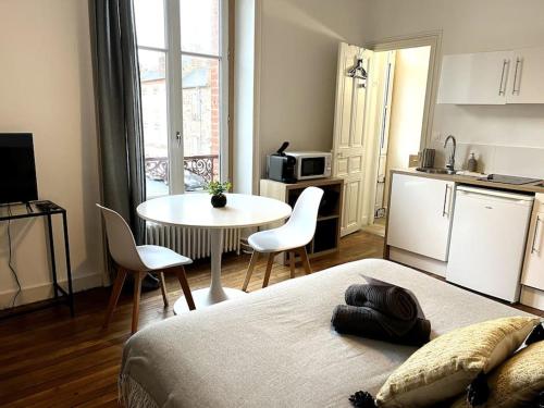 une chambre avec un lit et une table et une cuisine dans l'établissement Joli studio au calme proche Parc du Thabor/centre, à Rennes