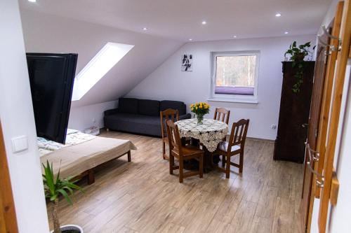 a living room with a table and chairs and a couch at Buczylas Siedlisko in Tuchomie