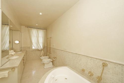 a bathroom with a tub and a toilet and a sink at Villa San Carlo - Gardagate in Roe