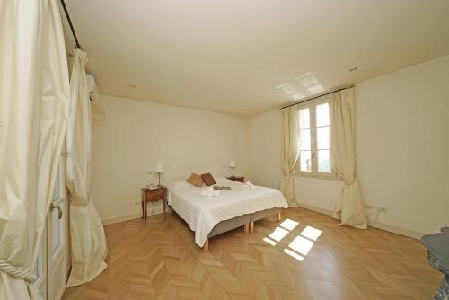 a white bedroom with a bed and a window at Villa San Carlo - Gardagate in Roe