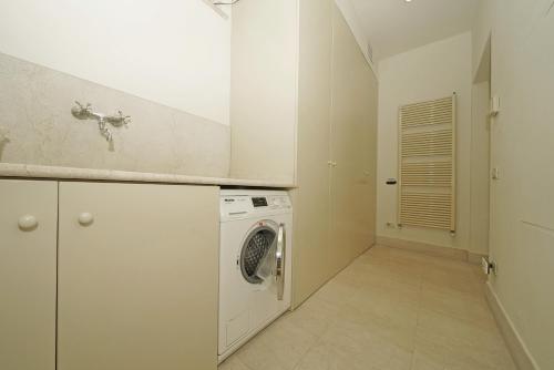 a white laundry room with a washer and dryer at Villa San Carlo - Gardagate in Roe