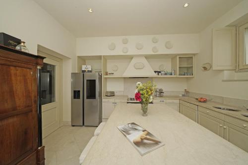 a kitchen with a table with a vase of flowers on it at Villa San Carlo - Gardagate in Roe