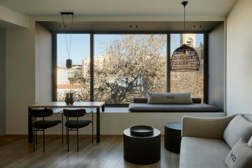 a living room with a table and a large window at Athens Woo Suites in Athens