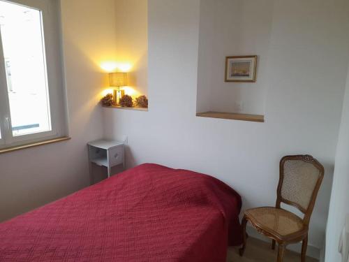 - une chambre avec un lit rouge et une chaise dans l'établissement Grand, clair, central, élégant, 2 chambres, 5 minutes de la gare, à Limoges