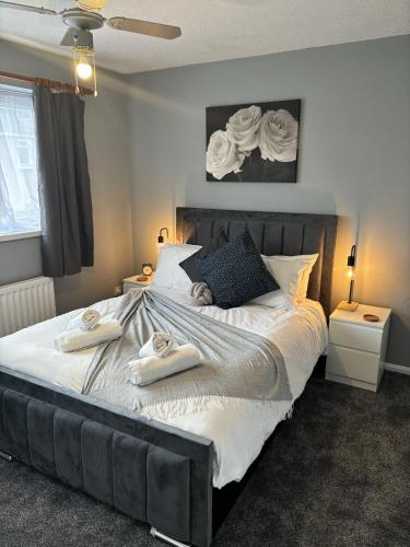 a bedroom with a large bed with towels on it at Cosy Corner - 2 bed house with parking! in Southampton