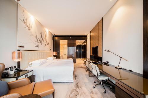 a hotel room with a bed and a desk at Hilton Shenzhen Futian, Metro Station at Hotel Front Door, Close to Futian Convention & Exhibition Center in Shenzhen