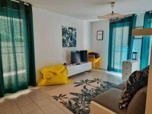 un salon avec un canapé et une télévision dans l'établissement Appartement 2 pers, terrasse, piscine, parking, à Saint-Rémy-de-Provence