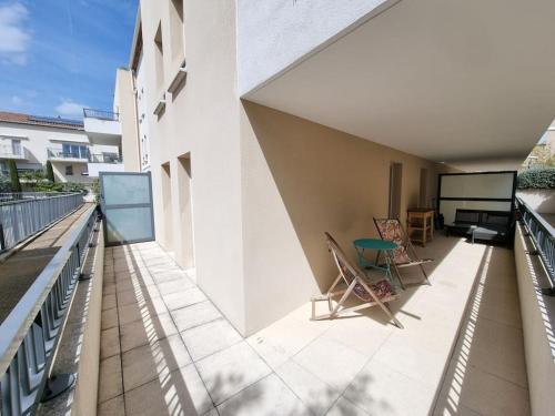 un balcon avec des chaises et une table sur un immeuble dans l'établissement Appartement 2 pers, terrasse, piscine, parking, à Saint-Rémy-de-Provence