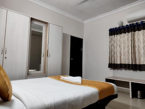 a white room with a bed and a window at Luxor Park Service Apartment in Hyderabad