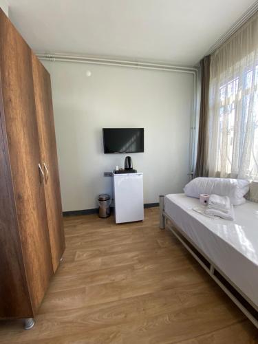 een slaapkamer met een bed en een tv aan de muur bij Ferah Otel in Istanbul