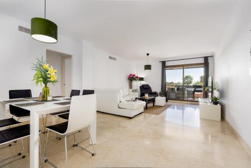 uma sala de estar branca com uma mesa e cadeiras em Casares Costa Gem: 2BR with Pool em Bahia de Casares