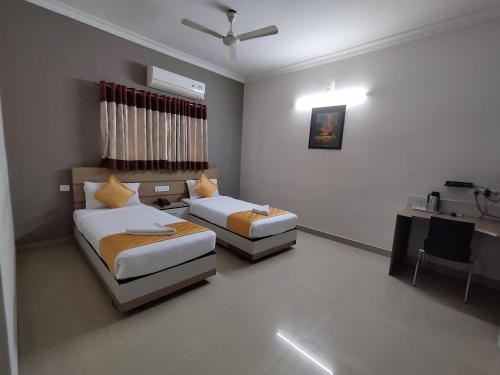 a hotel room with two beds and a sink at Luxor Park Service Apartment in Hyderabad