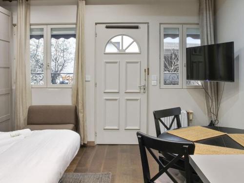 une chambre avec un lit, un bureau et une télévision dans l'établissement La Villa du Louvre, à Paris