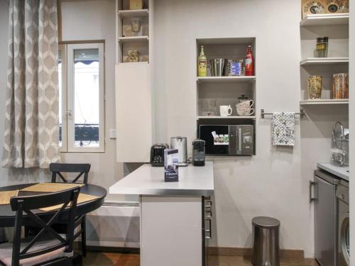 une cuisine avec un comptoir et une table avec des chaises dans l'établissement La Villa du Louvre, à Paris