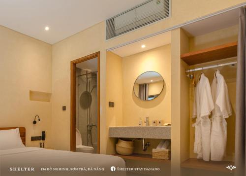 a bathroom with a bed and a sink and a mirror at Shelter Stay Da Nang in Da Nang