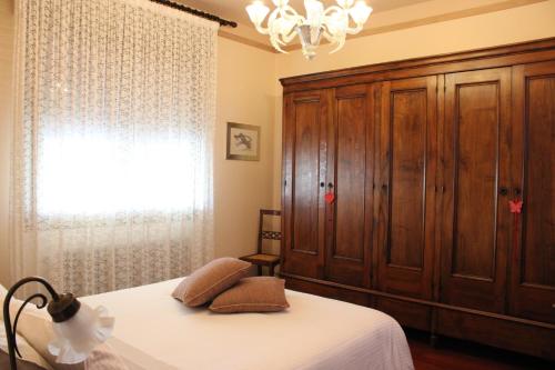 1 dormitorio con 1 cama y un gran armario de madera en Affittacamere Da Lina, en Vittorio Veneto