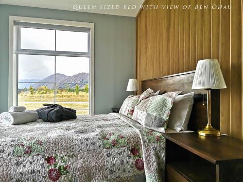 a bedroom with a bed with a desk and a window at Kahurangi Cottage Twizel in Twizel