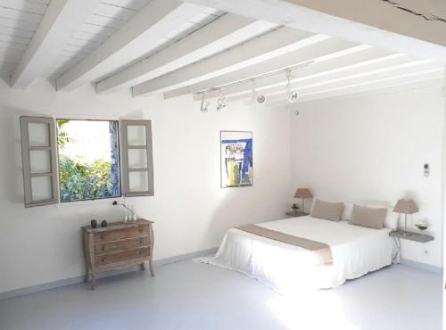 - une chambre blanche avec un lit et une fenêtre dans l'établissement LUXURY 270M² HOUSE OF CHARACTER IN OLD STONES WITH HEATED POOL, NEAR CALVI, à Calenzana