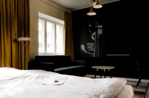ポリにあるOriginal Sokos Hotel Vaakuna Poriのベッドルーム1室(ベッド1台、ソファ、テーブル付)