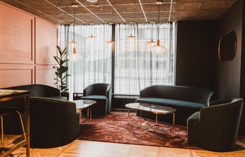 uma sala de espera com cadeiras, um sofá e mesas em Original Sokos Hotel Vaakuna Pori em Pori