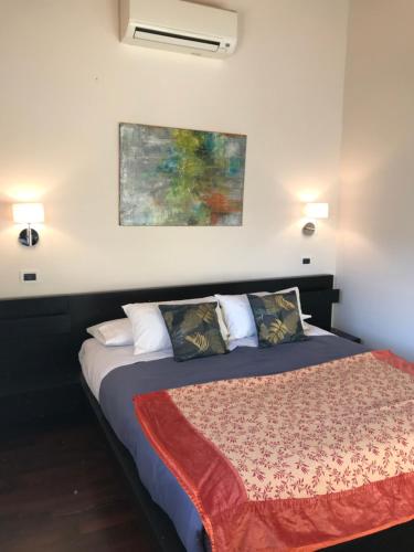 1 dormitorio con 1 cama con una pintura en la pared en Villa Marlene B&B, en Albenga
