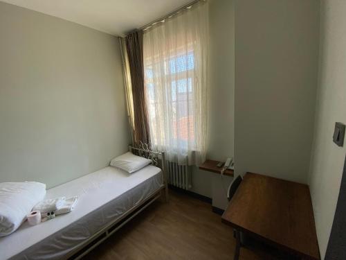 a small room with a bed and a window at Ferah Hostel in Istanbul