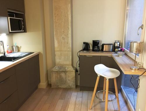 - une cuisine avec un comptoir et un tabouret dans une pièce dans l'établissement L'Aparté, à Nancy